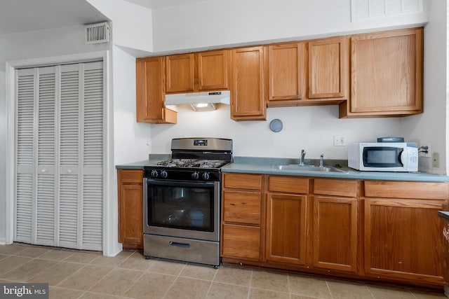 kitchen featuring sink, gas stove, and light tile patterned flooring