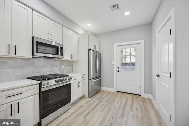 kitchen featuring tasteful backsplash, stainless steel appliances, and white cabinets