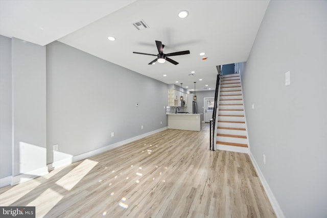 unfurnished living room with light hardwood / wood-style flooring and ceiling fan