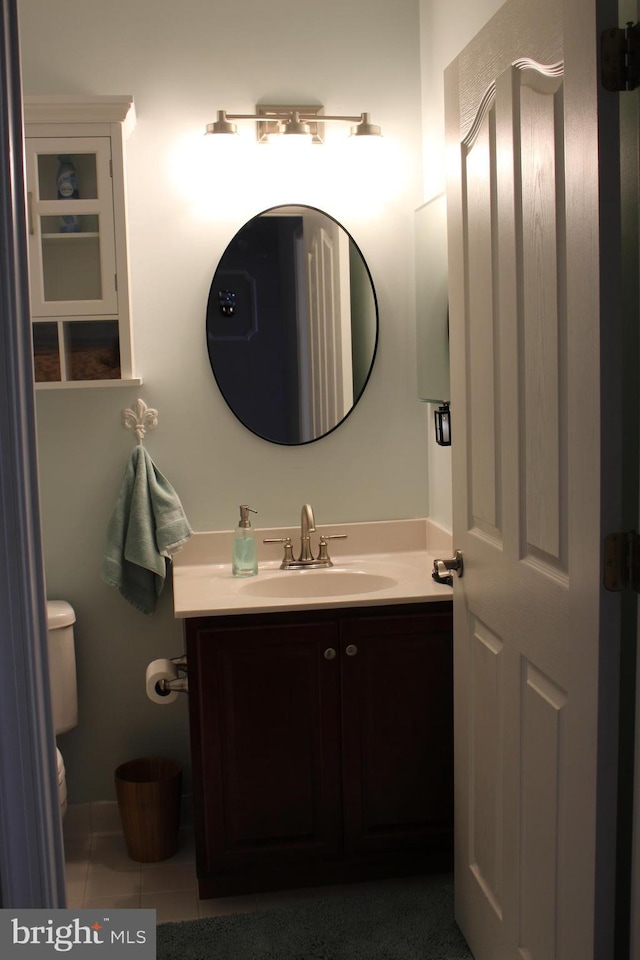 bathroom featuring tile patterned flooring, vanity, and toilet