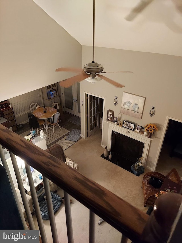 carpeted living room with high vaulted ceiling and ceiling fan