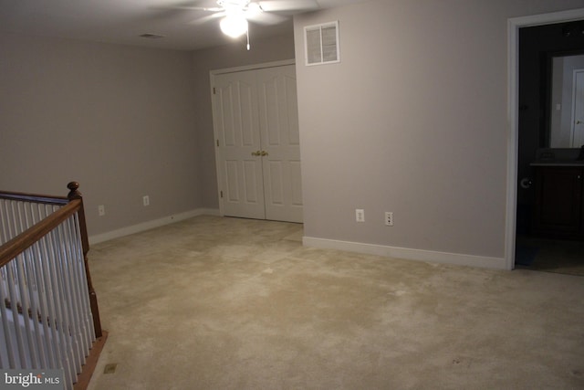 carpeted spare room with ceiling fan