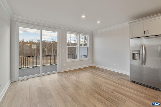 unfurnished dining area featuring ornamental molding and light wood-type flooring