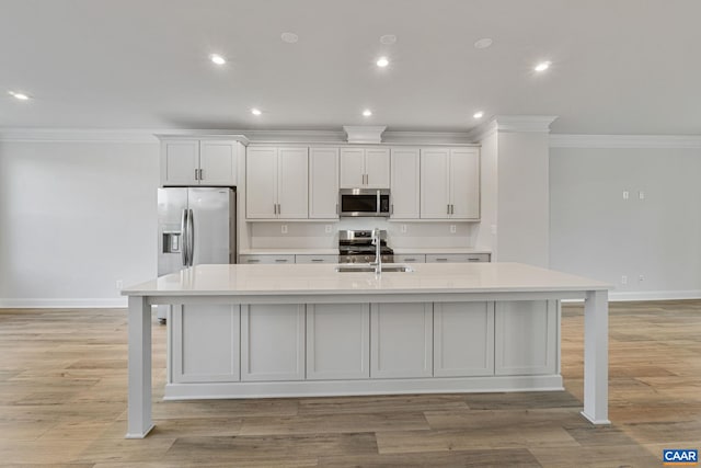 kitchen featuring white cabinetry, a kitchen bar, a large island with sink, and appliances with stainless steel finishes