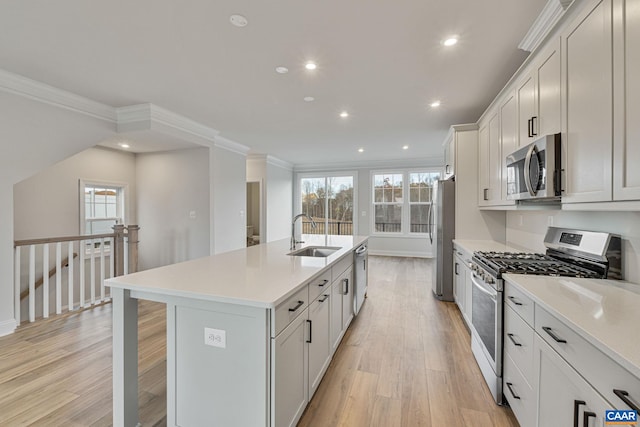 kitchen featuring sink, appliances with stainless steel finishes, an island with sink, a wealth of natural light, and white cabinets