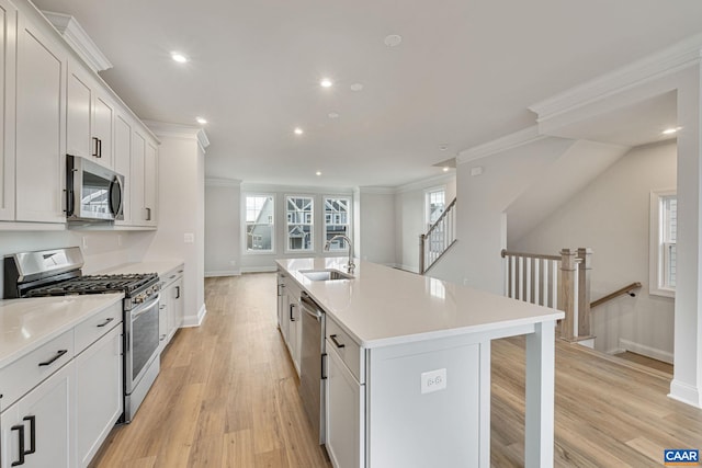 kitchen featuring white cabinetry, appliances with stainless steel finishes, sink, and a kitchen island with sink