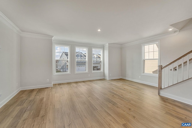 unfurnished room featuring ornamental molding, a healthy amount of sunlight, and light wood-type flooring