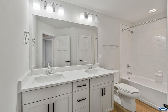 full bathroom featuring vanity, toilet, tiled shower / bath combo, and hardwood / wood-style floors