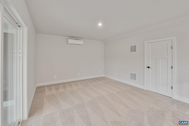 spare room with light colored carpet and an AC wall unit