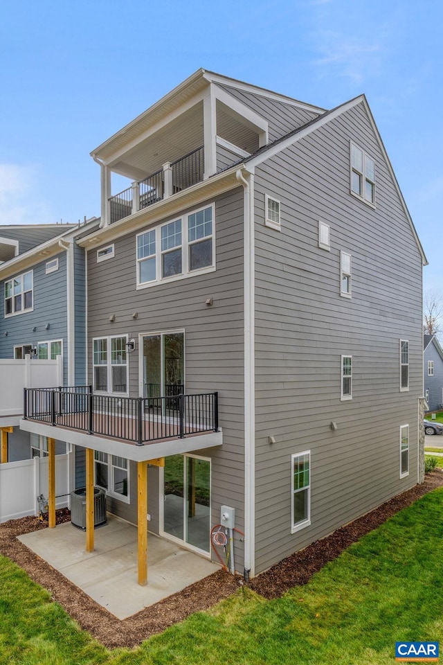 back of house featuring a lawn, a patio, a balcony, and central air condition unit