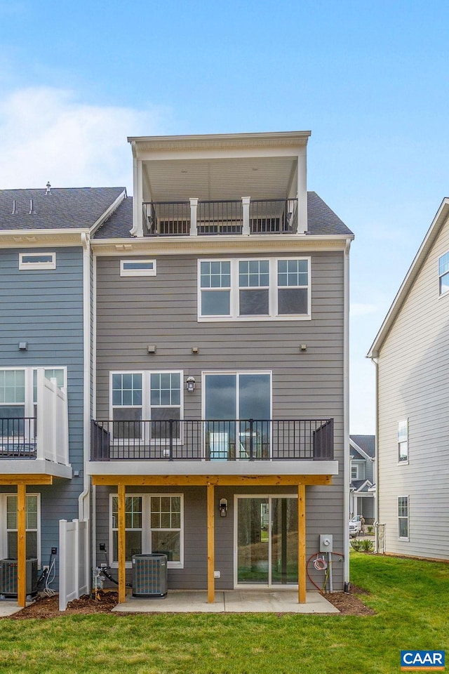 rear view of property featuring a yard, a patio area, and central air condition unit