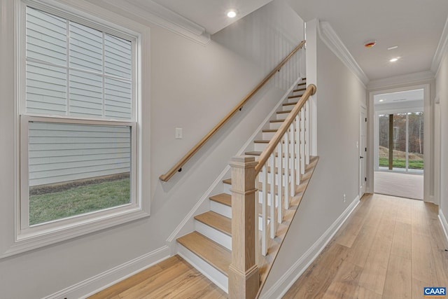 stairs featuring crown molding and hardwood / wood-style floors