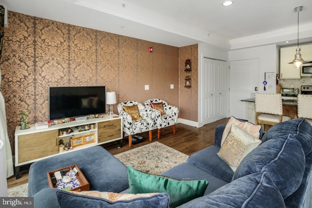 living room with a raised ceiling, dark hardwood / wood-style floors, and wood walls