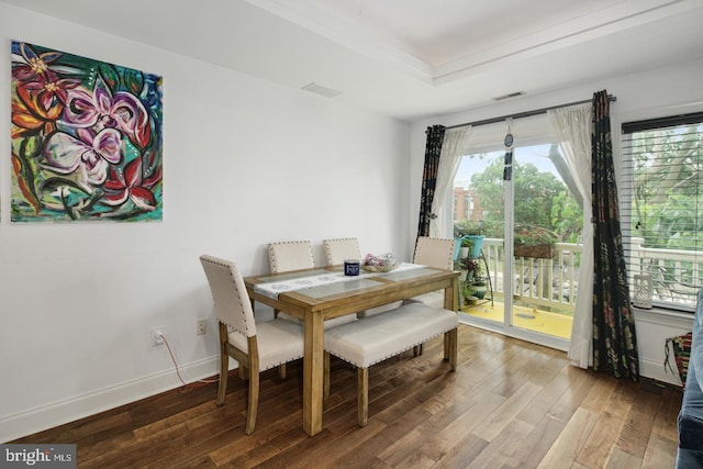 dining room featuring hardwood / wood-style flooring and a raised ceiling