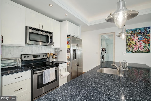 kitchen with sink, appliances with stainless steel finishes, dark stone counters, decorative backsplash, and white cabinets