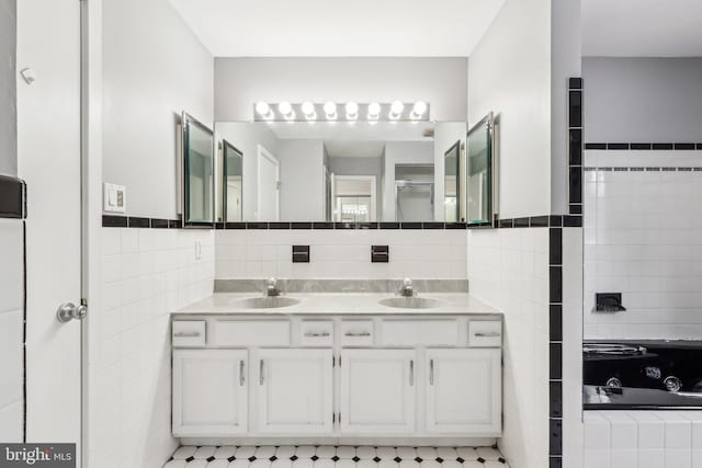 bathroom featuring tile walls, vanity, and a relaxing tiled tub