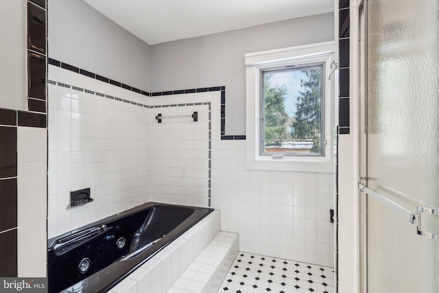 bathroom featuring tile patterned floors, plus walk in shower, and tile walls