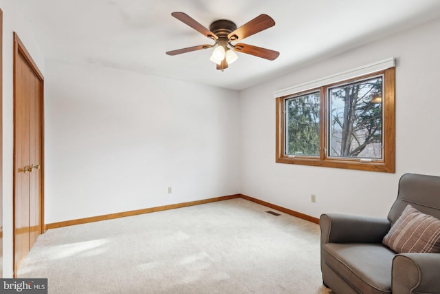 living area with ceiling fan and carpet