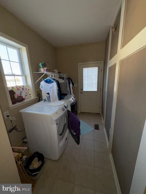 washroom with separate washer and dryer and light tile patterned floors