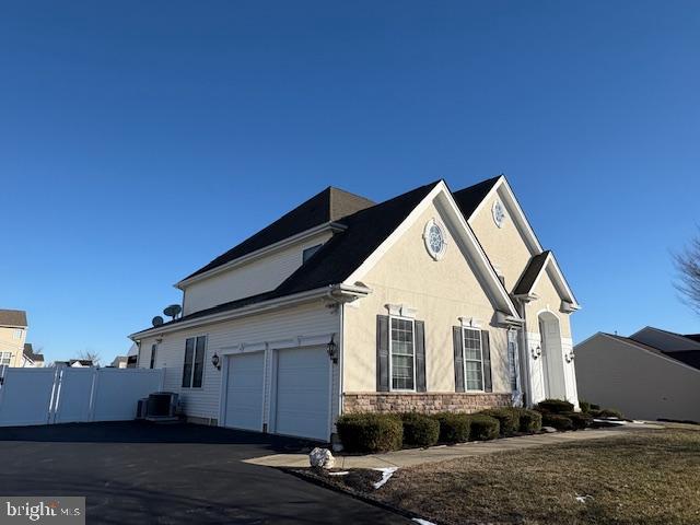 view of side of property featuring cooling unit and a garage