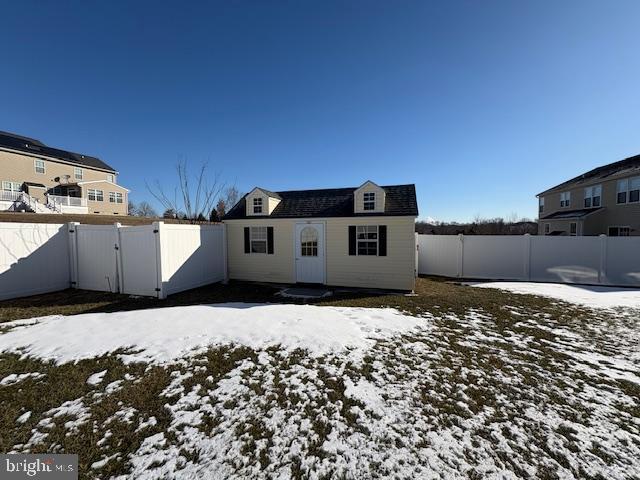 view of snow covered back of property