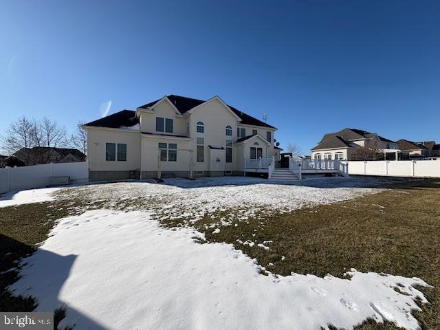 snow covered rear of property featuring a deck