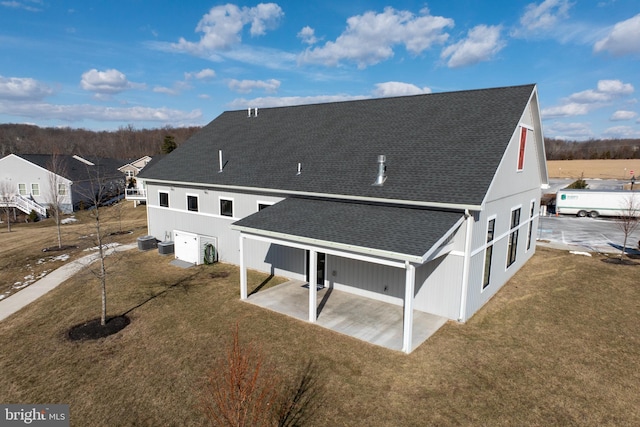 back of property with central AC unit, a patio area, and a lawn