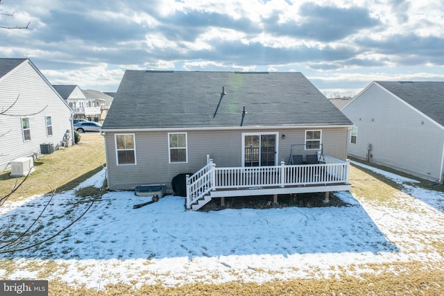 snow covered property with a wooden deck and central AC unit