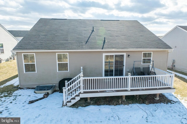 snow covered house featuring a deck