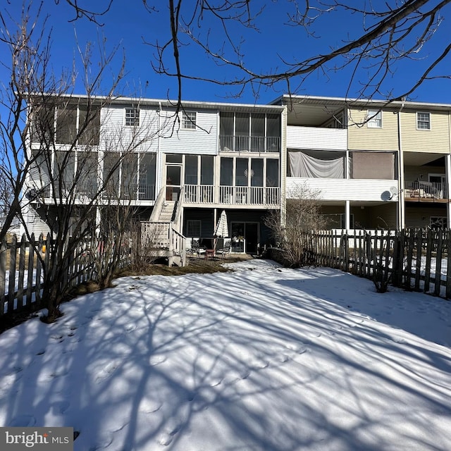 view of snow covered back of property