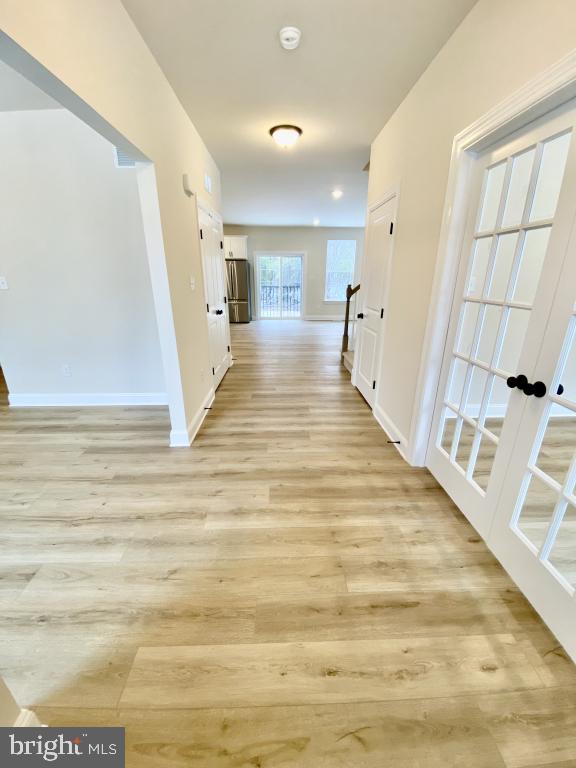 hall featuring french doors and light hardwood / wood-style flooring