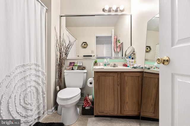 bathroom featuring tile patterned flooring, vanity, and toilet