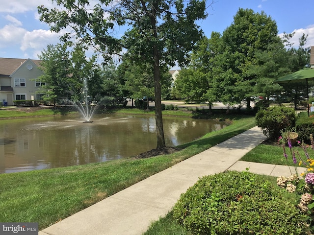 surrounding community with a water view and a yard