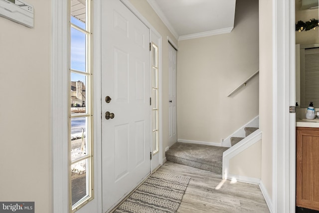 entrance foyer with crown molding and light wood-type flooring