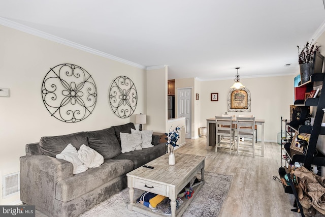 living room featuring ornamental molding and light hardwood / wood-style flooring