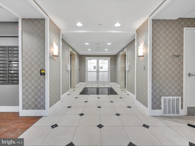 corridor featuring light tile patterned floors and french doors