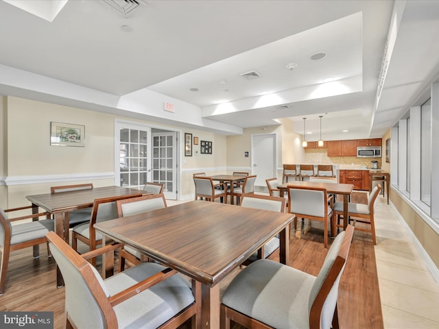 dining area with light hardwood / wood-style flooring and french doors