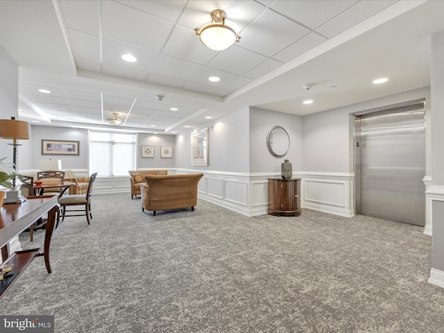 interior space with elevator, carpet, and a drop ceiling