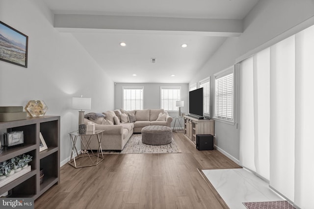 living room featuring wood-type flooring and lofted ceiling with beams