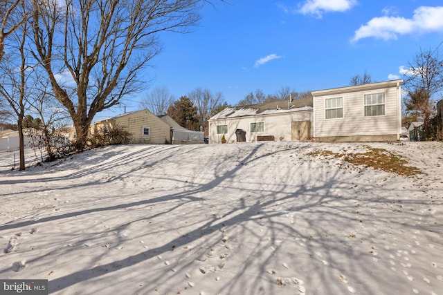 view of snow covered back of property