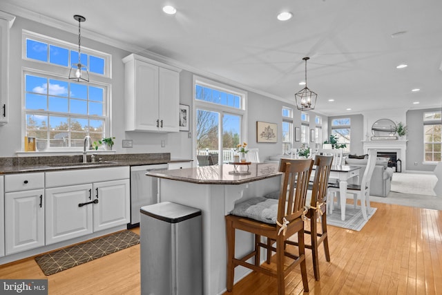 kitchen featuring white cabinetry, sink, pendant lighting, and stainless steel dishwasher