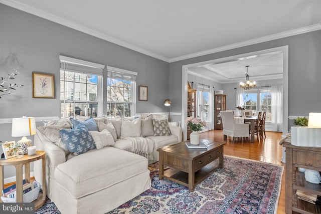 living room featuring crown molding, hardwood / wood-style floors, and a notable chandelier