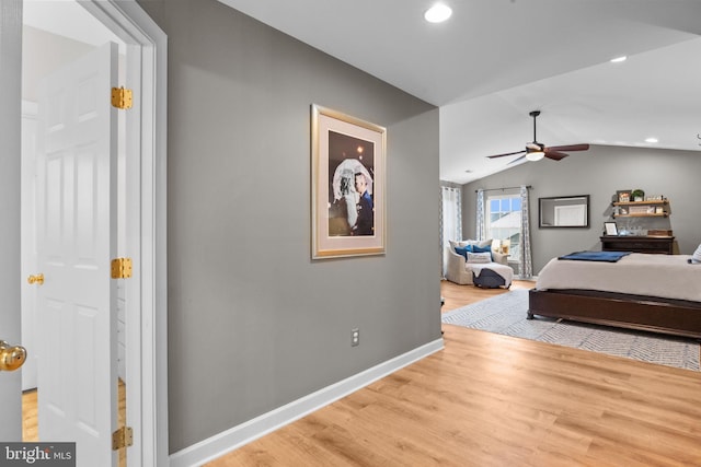 bedroom with lofted ceiling, ceiling fan, and light wood-type flooring