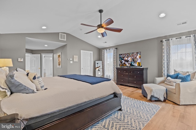 bedroom featuring ceiling fan, multiple windows, lofted ceiling, and light hardwood / wood-style flooring