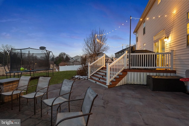 patio terrace at dusk with a trampoline and a wooden deck