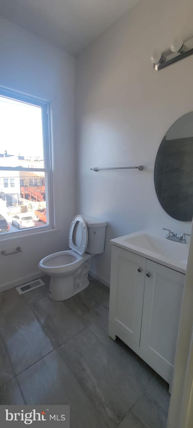 bathroom featuring tile patterned flooring, vanity, and toilet