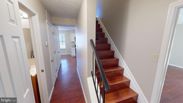 stairway with hardwood / wood-style flooring and a textured ceiling