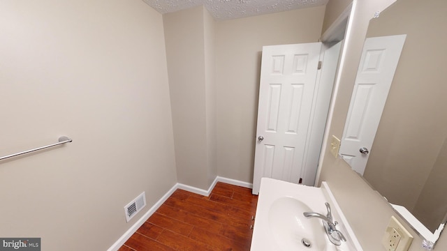 12459 Charter Oak Ct, Waldorf, MD 20601 - bathroom with sink, hardwood / wood-style floors, and a textured ceiling