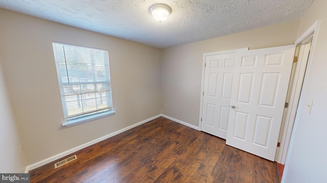12459 Charter Oak Ct, Waldorf, MD 20601 - unfurnished bedroom featuring dark hardwood / wood-style flooring, a closet, and a textured ceiling