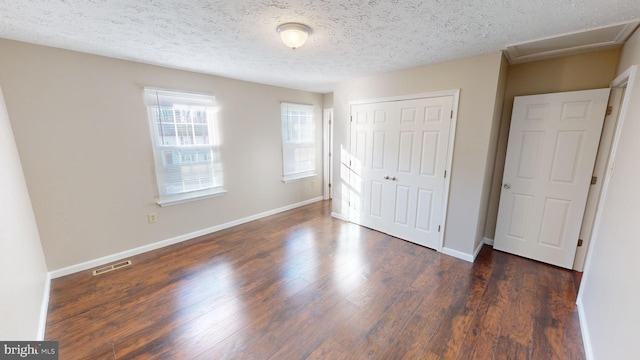 12459 Charter Oak Ct, Waldorf, MD 20601 - unfurnished bedroom featuring dark hardwood / wood-style flooring, a closet, and a textured ceiling